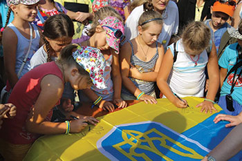 Діти учасників війни з Херсонщини розмалювали прапор України.