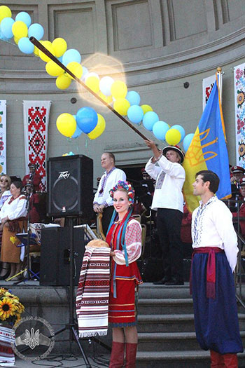 Хор „Трембіта“ виконує гимни США та України, а танцювальний ансамбль готується до вітального танцю з хлібом і сіллю. 